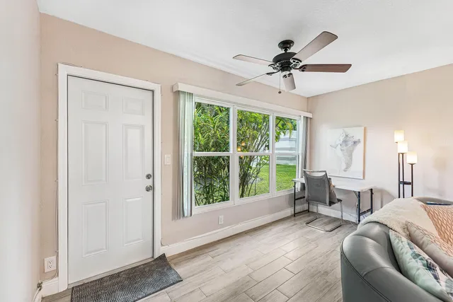 a living room with furniture ceiling fan and a window