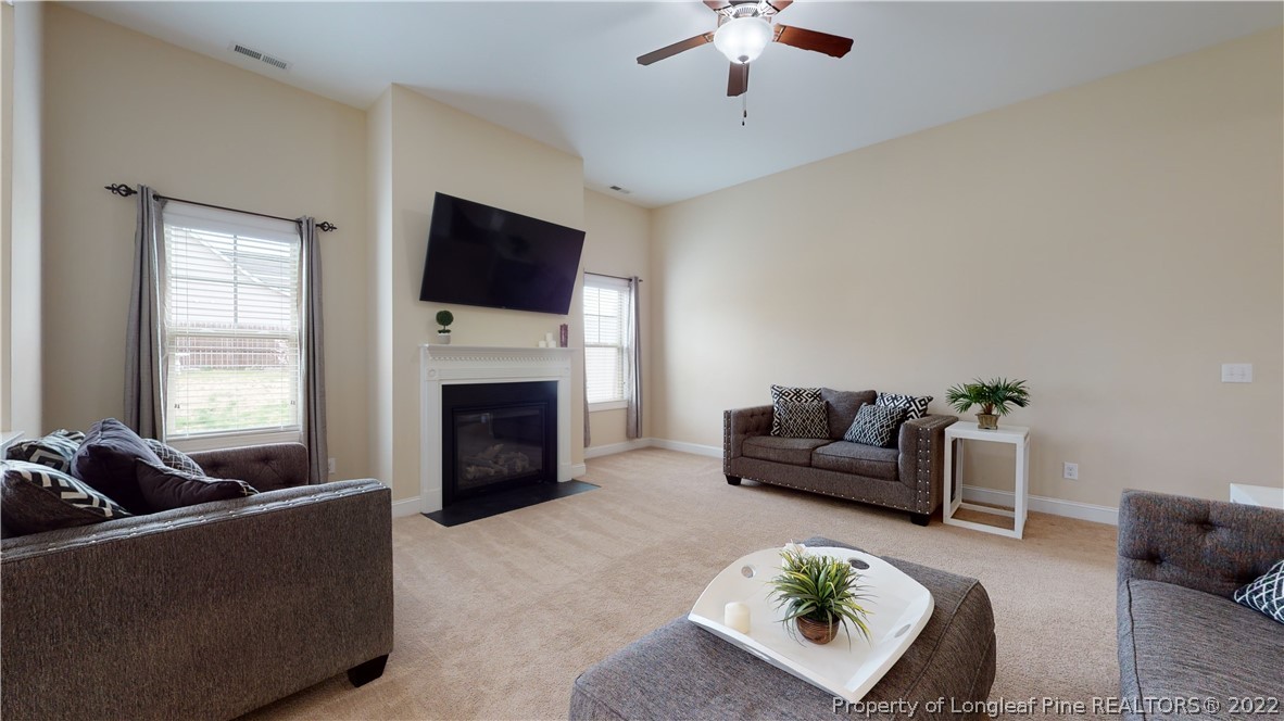 109 Caulfield Road Aberdeen, NC 28315 - Photo 7 of 28 a living room with furniture a fireplace and a flat screen tv