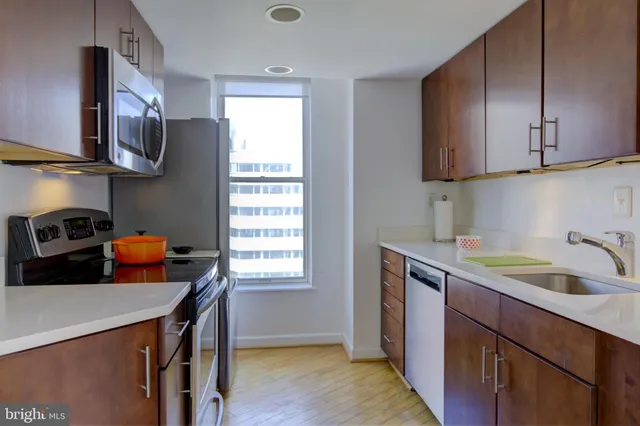 a kitchen with stainless steel appliances granite countertop a sink a stove and a refrigerator