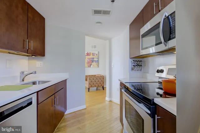 a kitchen with stainless steel appliances a sink a stove and a microwave