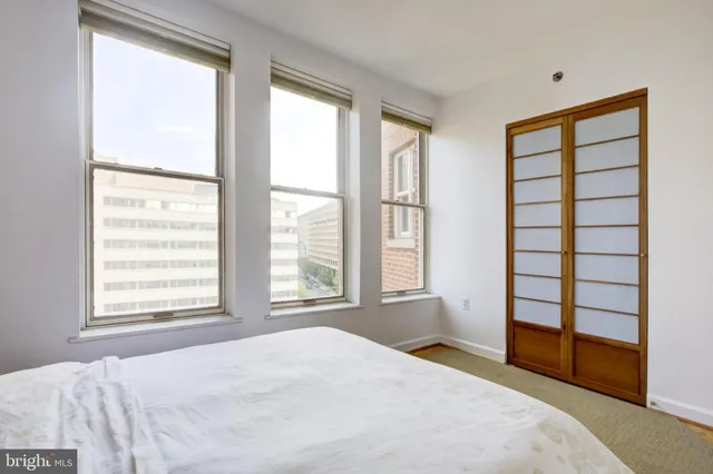 a bedroom with a bed and a large window