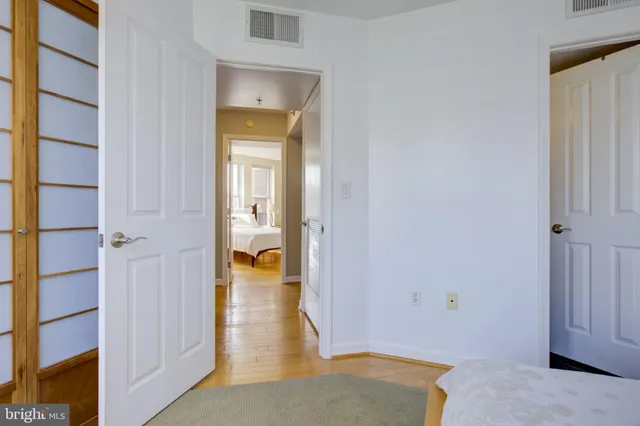 a view of a hallway with wooden floor and a living room