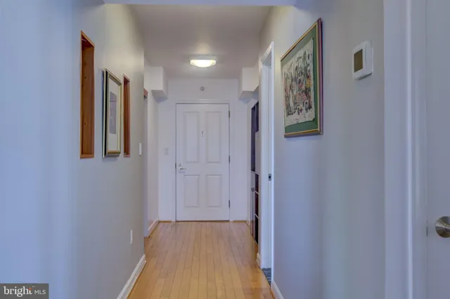 a view of a hallway with wooden floor