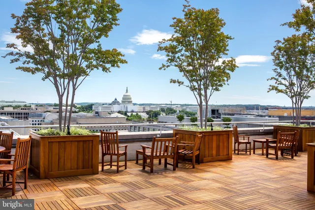 a dining room with wooden floor a chandelier a glass table and chairs