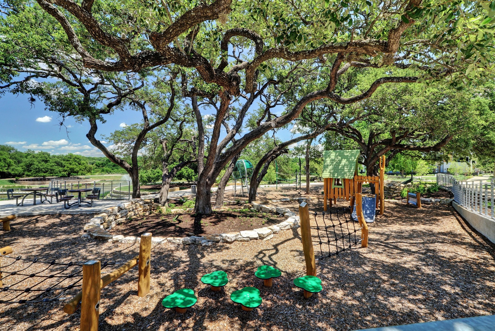 4515 Unity Circle Austin, TX 78731 - Photo 27 of 37 Mature shade trees canopy a custom play structure and outdoor recreation area.