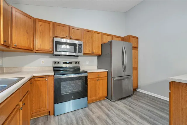 a kitchen with stainless steel appliances granite countertop a refrigerator stove top oven and sink