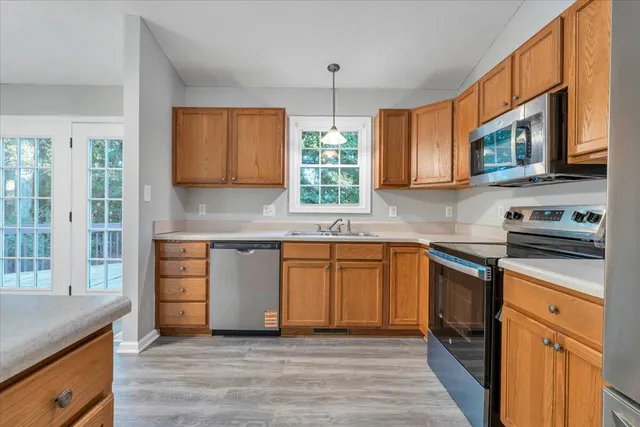 a kitchen with stainless steel appliances granite countertop a stove a sink and a microwave