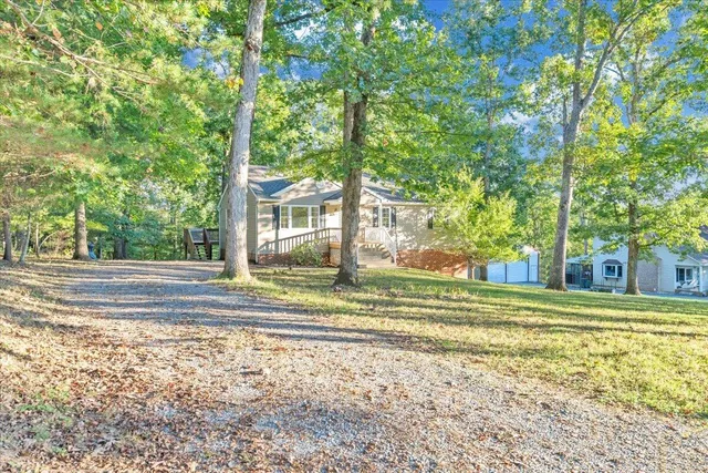 a view of a house with backyard and trees