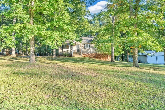 a view of a house with garden and trees
