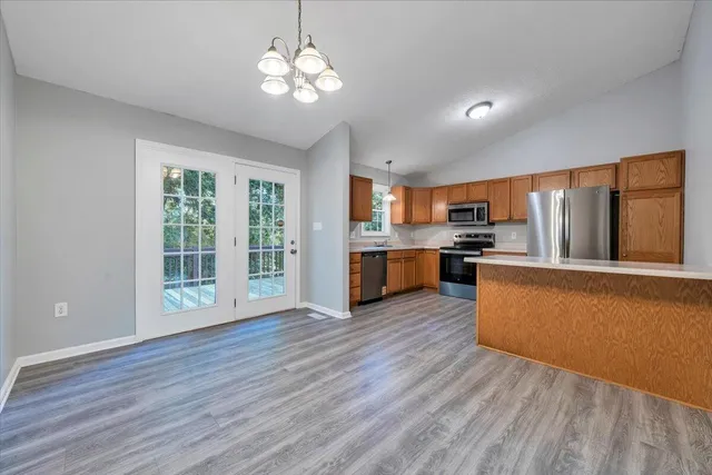 a view of kitchen with granite countertop stainless steel appliances cabinets and wooden floor