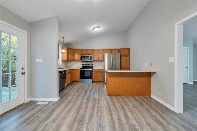 a kitchen with wooden floors and wooden cabinets