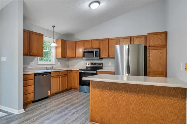 a kitchen with stainless steel appliances granite countertop a refrigerator stove top oven and sink