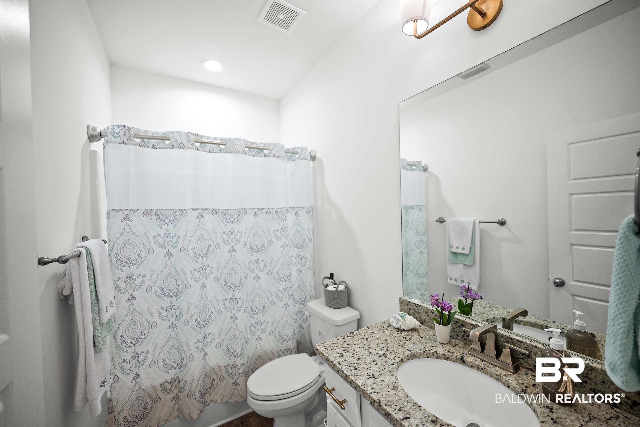 2651 South Juniper Street, Unit 2002 Foley, AL 36535 - Photo 16 of 23 Bathroom featuring a granite countertop vanity with an undermount sink, a large wall mirror, and a full shower with a patterned curtain