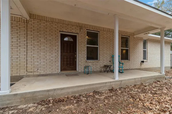 a view of a house with a door and wooden bench