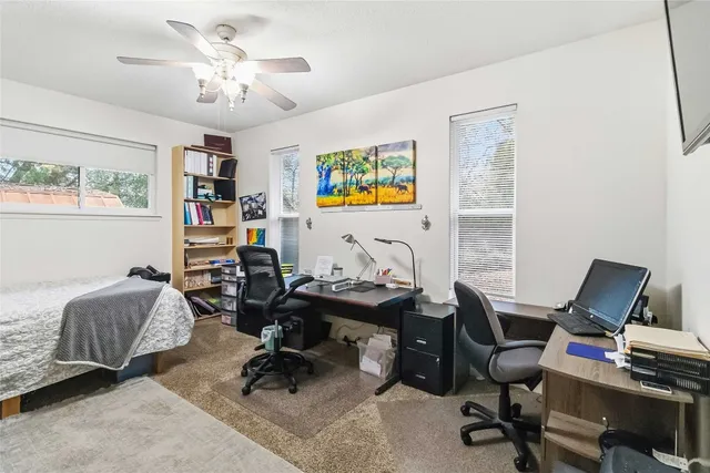 a view of a workspace with furniture and a window
