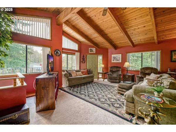 a living room with furniture floor to ceiling window and a table