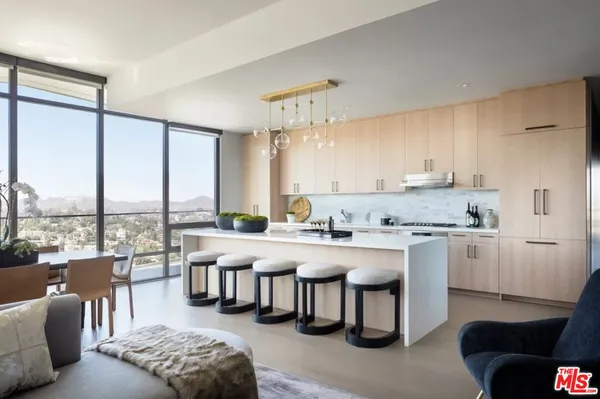 a kitchen with stainless steel appliances granite countertop a stove a sink dishwasher and white cabinets with wooden floor