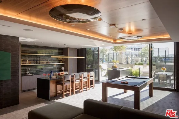 a living room with furniture a ceiling fan and a floor to ceiling window