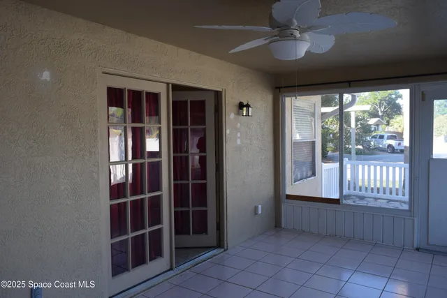 an empty room with a chandelier fan and a bathroom