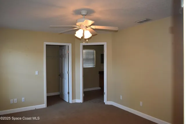 a view of a chandelier fan and entryway