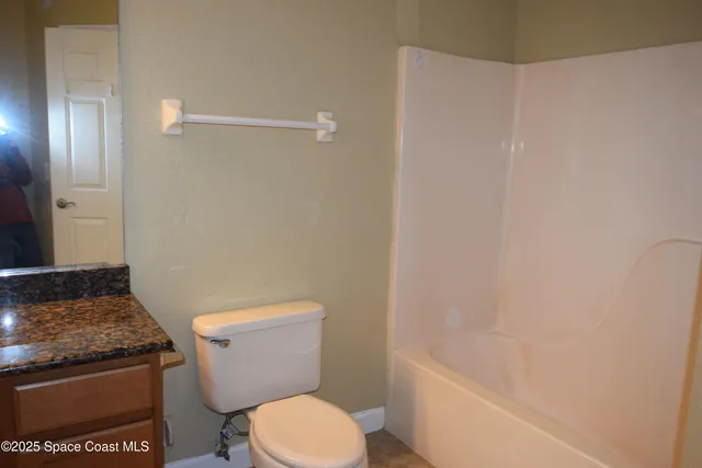 a white toilet sitting next to a bath tub