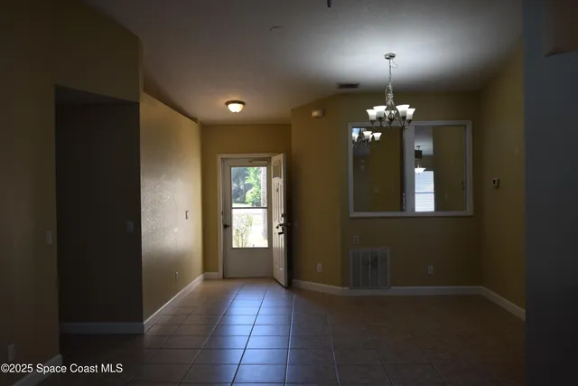 a view of a hallway with windows and chandelier