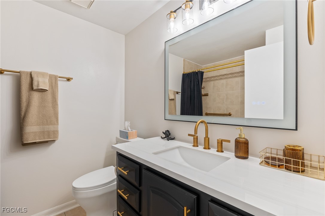 170 5th Street South Naples, FL 34113 - Photo 13 of 23 a bathroom with a granite countertop sink a toilet and mirror
