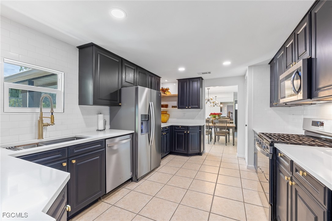 170 5th Street South Naples, FL 34113 - Photo 7 of 23 a kitchen with stainless steel appliances granite countertop a stove top oven a sink dishwasher a refrigerator and a cabinets