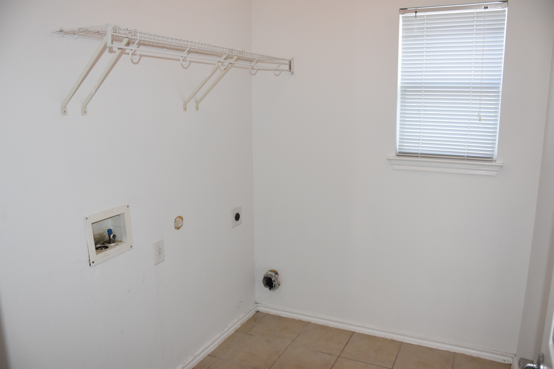 11300 Dimmit Street Manor, TX 78653 - Photo 7 of 23 A well-organized laundry space features practical wire shelving and abundant natural light.