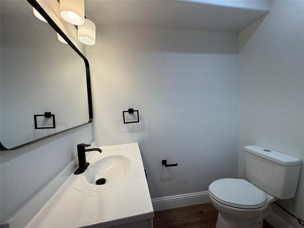 2909 Alexander Avenue Waco, TX 76708 - Photo 18 of 27 Bathroom featuring vanity, dark wood-style flooring, and a textured wall