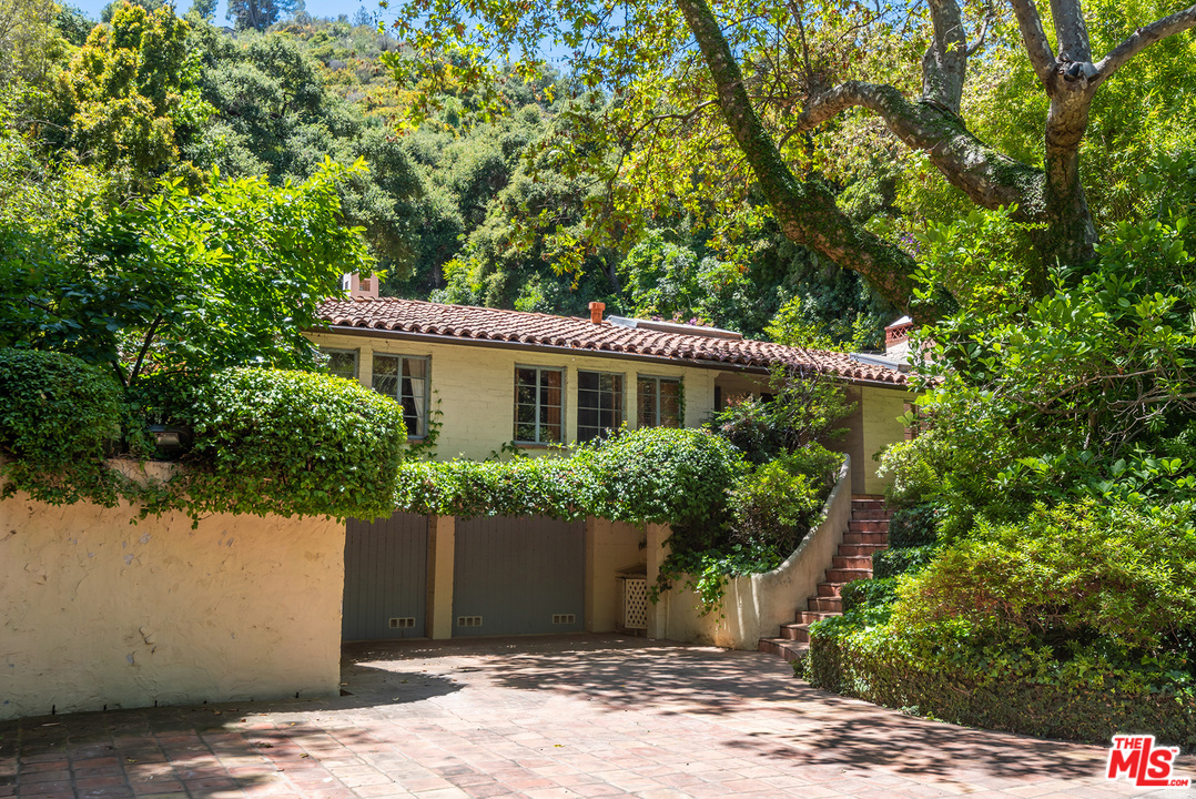 1491 Stone Canyon Road Los Angeles, CA 90077 - Photo 1 of 27 a view of a house with potted plants and large trees
