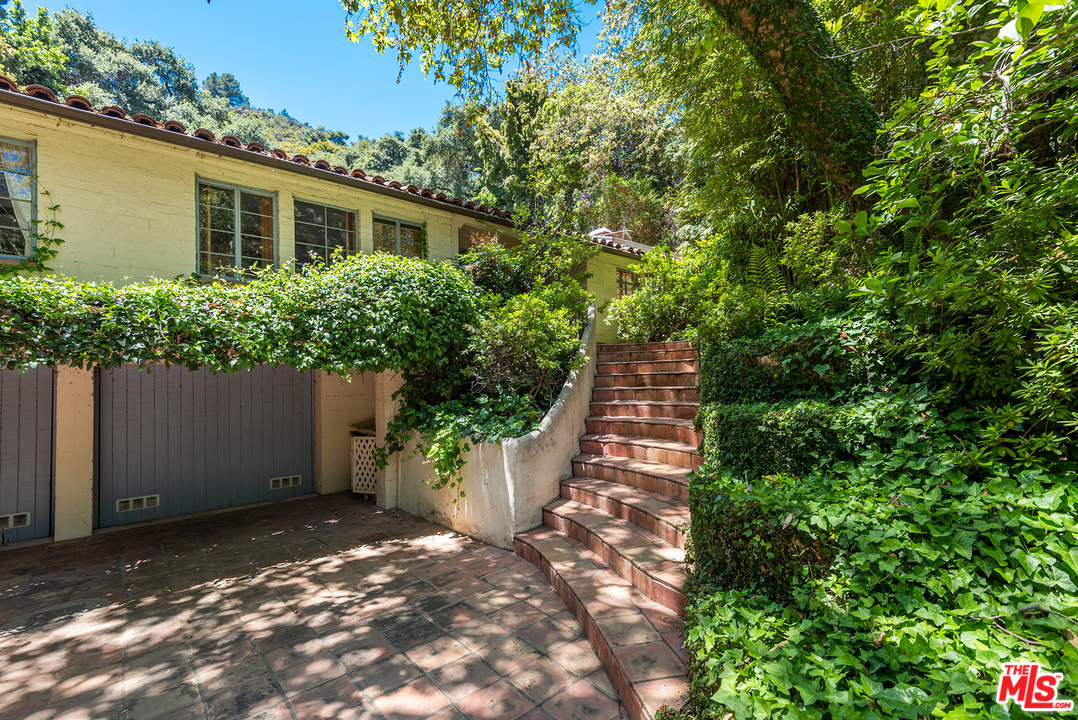 1491 Stone Canyon Road Los Angeles, CA 90077 - Photo 2 of 27 a view of a backyard with potted plants and large trees