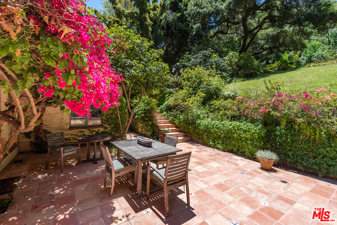 1491 Stone Canyon Road Los Angeles, CA 90077 - Photo 13 of 27 a backyard of a house with yard and outdoor seating