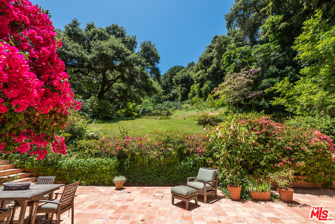 1491 Stone Canyon Road Los Angeles, CA 90077 - Photo 14 of 27 a backyard of a house with lots of green space and plants