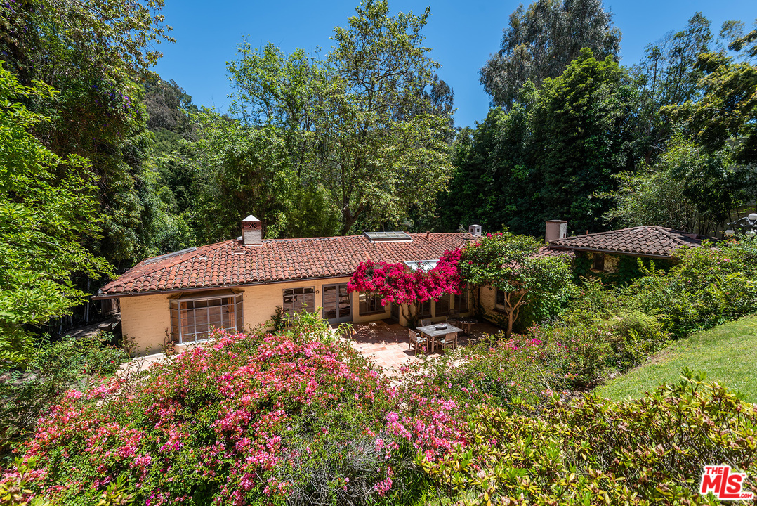1491 Stone Canyon Road Los Angeles, CA 90077 - Photo 3 of 27 a front view of a house with a yard and covered with flower plants