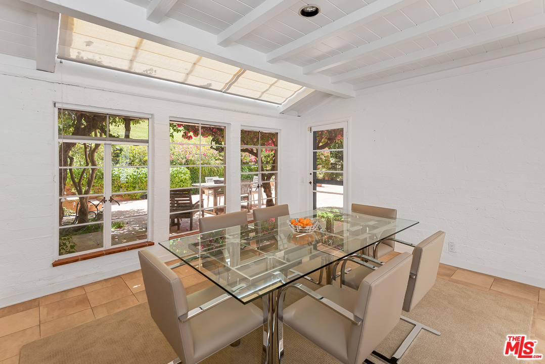 1491 Stone Canyon Road Los Angeles, CA 90077 - Photo 5 of 27 a view of a dining room with furniture large windows and wooden floor