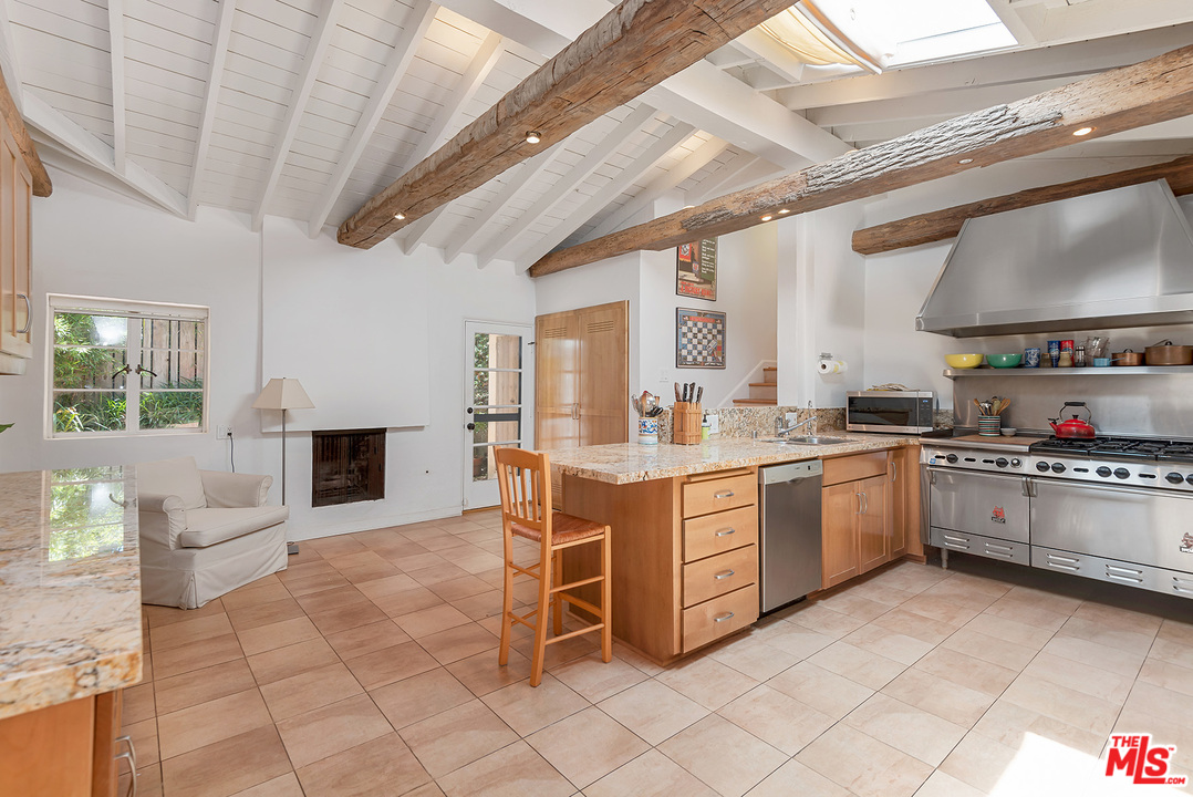 1491 Stone Canyon Road Los Angeles, CA 90077 - Photo 6 of 27 a kitchen with cabinets and chairs