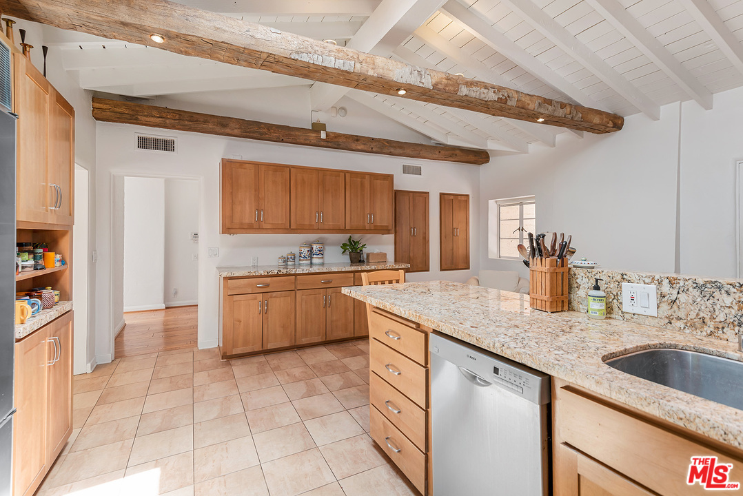 1491 Stone Canyon Road Los Angeles, CA 90077 - Photo 8 of 27 a kitchen with stainless steel appliances granite countertop a sink and cabinets