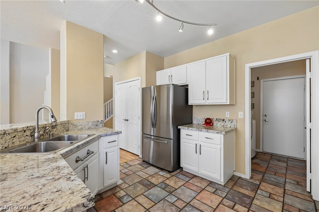 1727 Millstream Way Henderson, NV 89074 - Photo 19 of 46 Granite counters and stainless steel appliances complete this well-appointed kitchen with textured tile flooring.