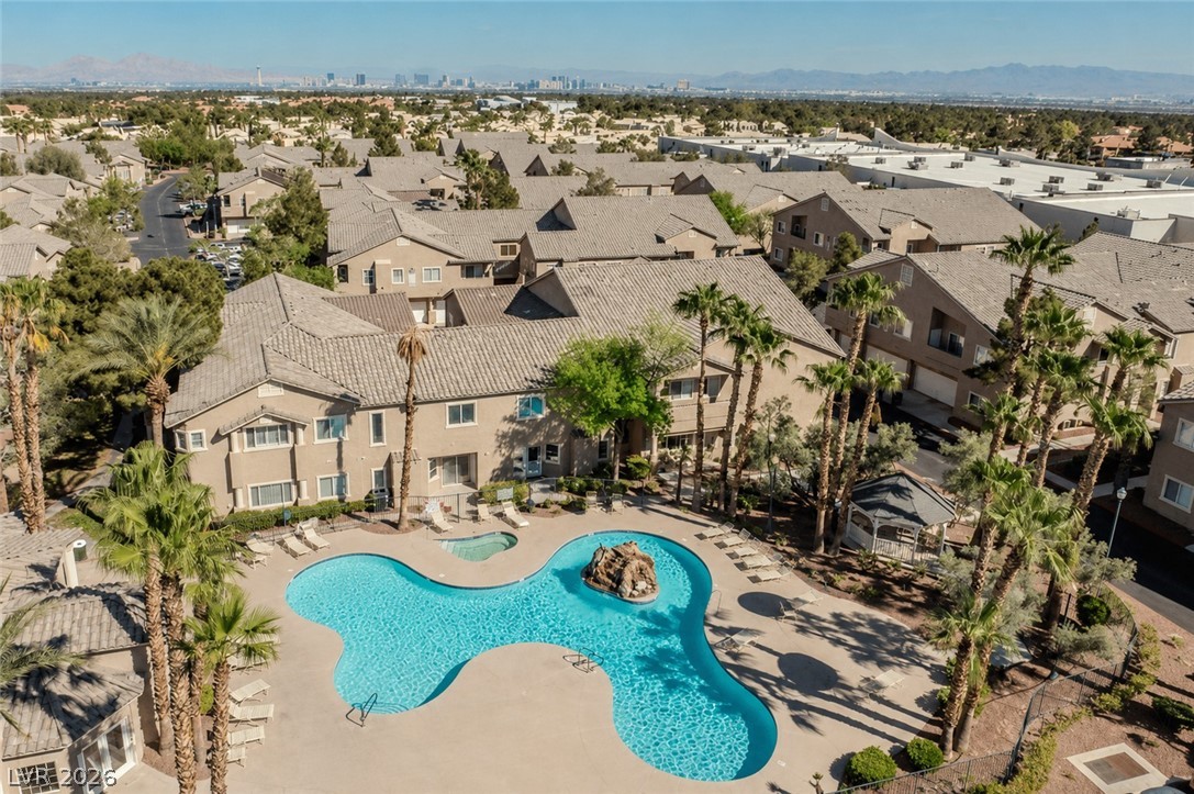 2153 Quarry Ridge Street, Unit 103 Las Vegas, NV 89117 - Photo 37 of 42 An aerial perspective reveals a serene pool with a rock formation, nestled among lush palm trees and multi-level residential structures.