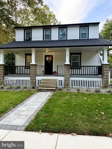 a view of a brick house with large windows and a yard