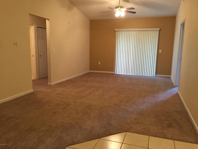 a view of a room with a ceiling fan and window