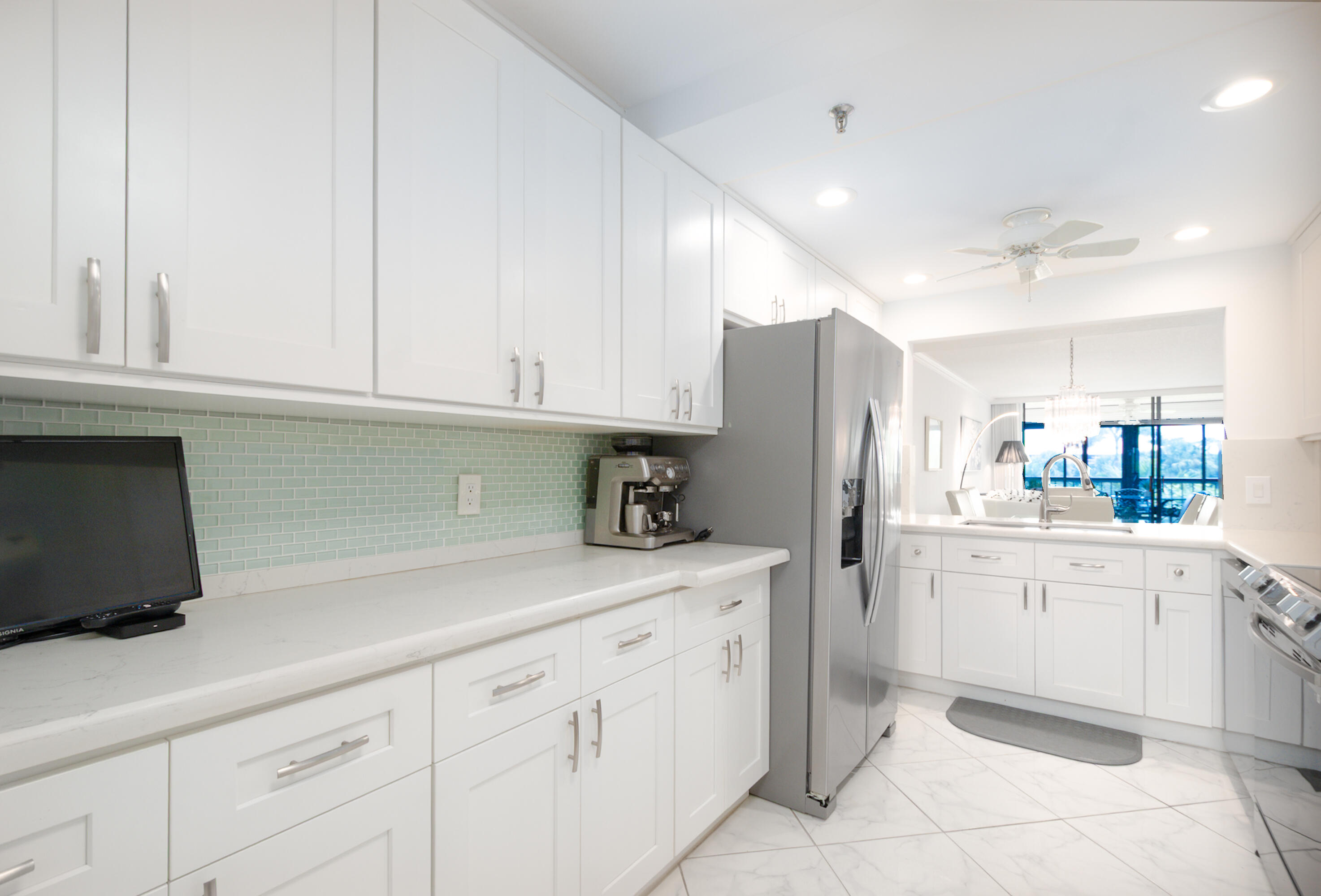 6420 Boca Del Mar Drive, Unit 308 Boca Raton, FL 33433 - Photo 9 of 37 a kitchen with white cabinets and refrigerator