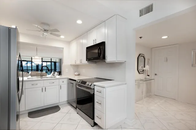 a kitchen with a sink stove and white cabinets