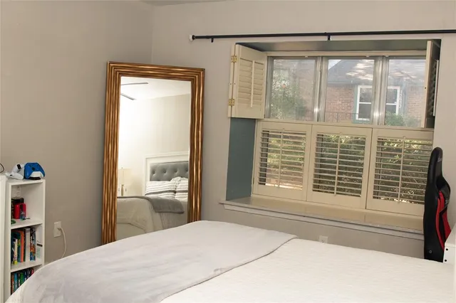 a bedroom with a bed and a large window