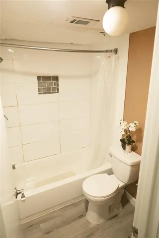 a bathroom with a toilet and a shower