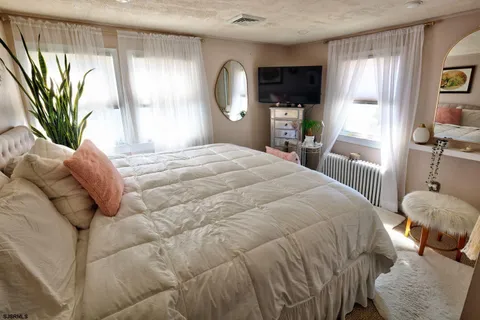 a bedroom with a bed and a large window