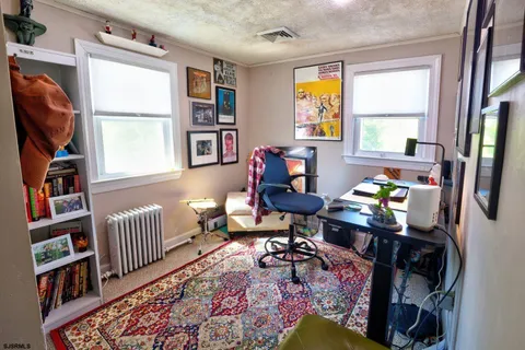 a living room with furniture a bookshelf and a window