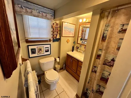 a white toilet sitting next to a bathroom sink and a shower