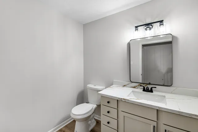a bathroom with a sink toilet and mirror